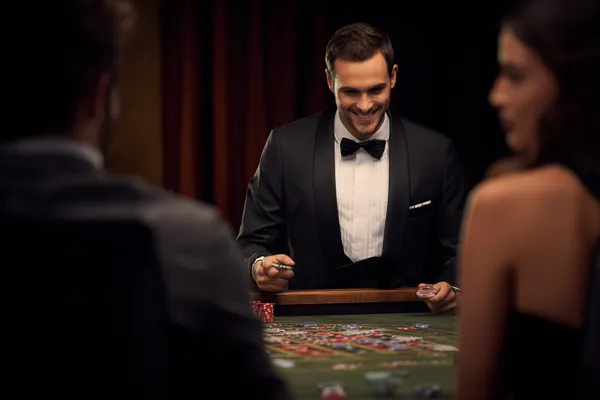 Một cô gái trong bộ váy xanh sang trọng đứng cạnh vòng roulette, gợi lên bầu không khí casino cao cấp của TR88.